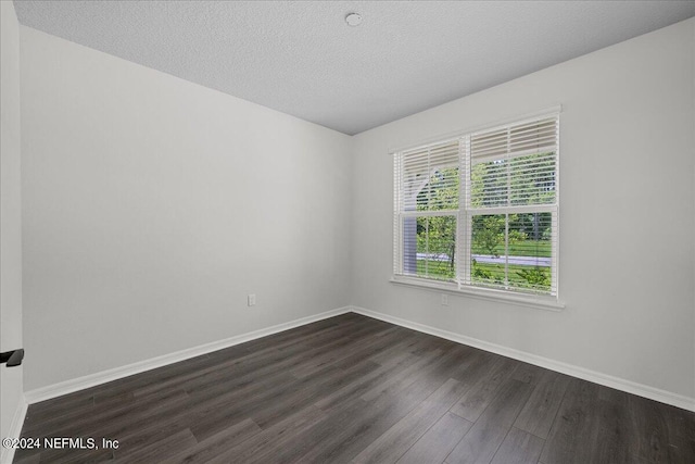 spare room with dark wood-type flooring and a textured ceiling