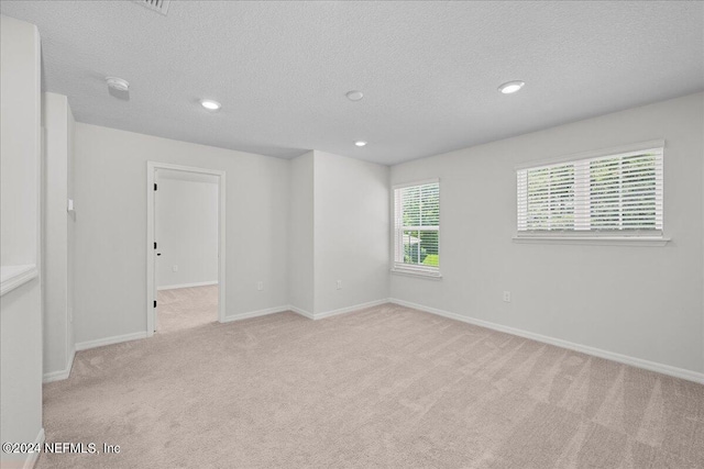 carpeted spare room featuring a textured ceiling