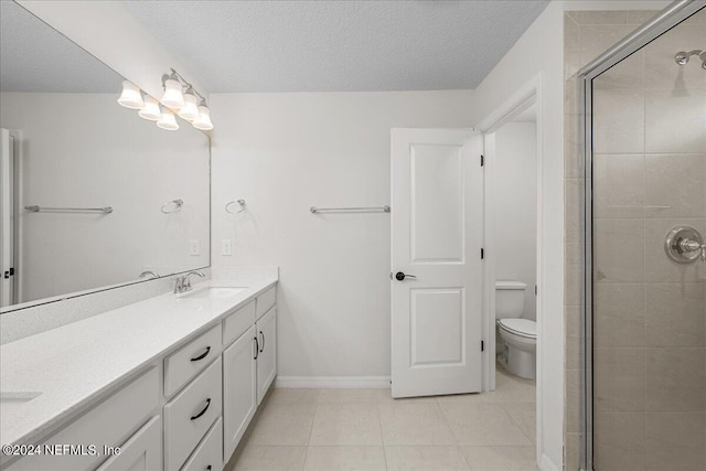 bathroom featuring toilet, tile flooring, large vanity, walk in shower, and a textured ceiling