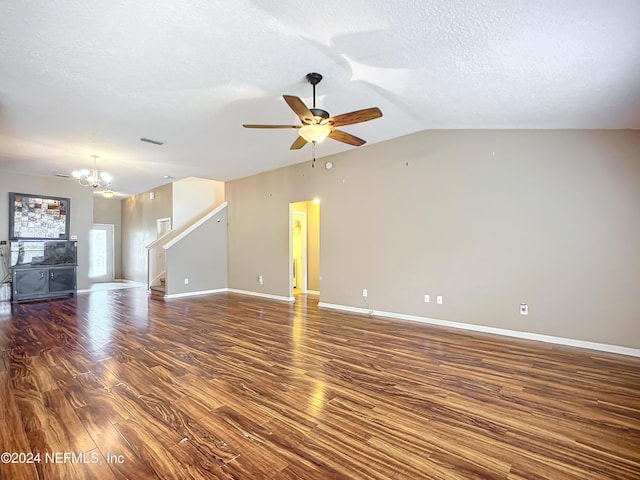 unfurnished living room featuring a textured ceiling, dark hardwood / wood-style floors, ceiling fan with notable chandelier, and vaulted ceiling