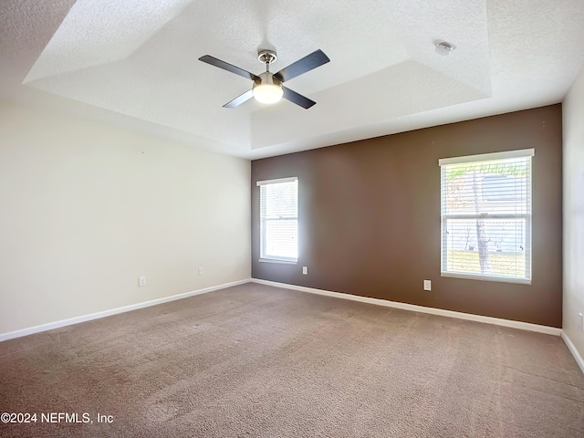 spare room featuring carpet floors, a wealth of natural light, and ceiling fan