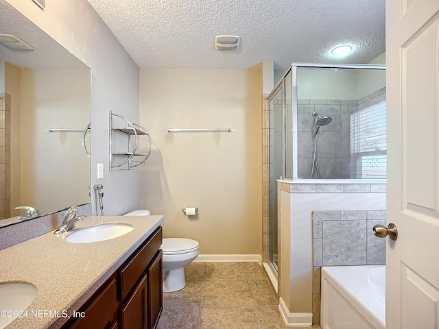 full bathroom featuring toilet, vanity, a textured ceiling, and separate shower and tub