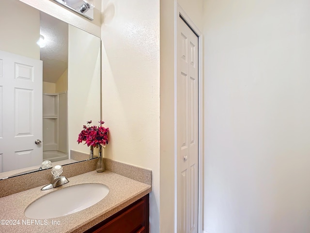 bathroom with a textured ceiling and vanity