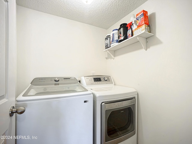 laundry room featuring a textured ceiling and separate washer and dryer