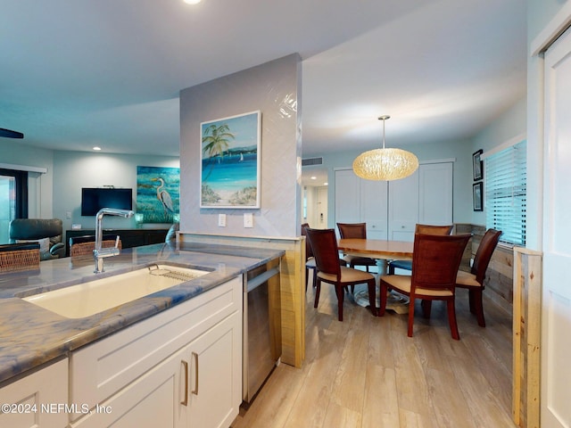 kitchen featuring decorative light fixtures, a chandelier, light hardwood / wood-style floors, stainless steel dishwasher, and sink