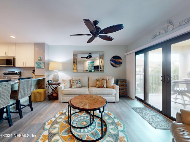 living room featuring french doors, light wood-type flooring, and ceiling fan