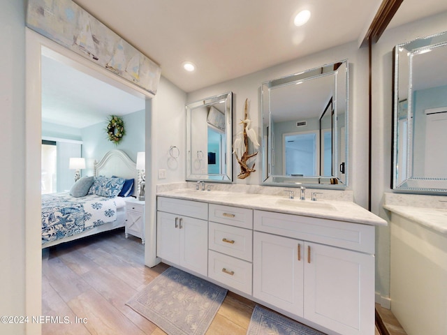 bathroom featuring hardwood / wood-style floors, oversized vanity, and double sink