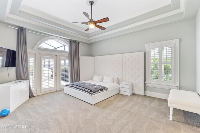 carpeted bedroom featuring access to exterior, ceiling fan, a raised ceiling, and crown molding