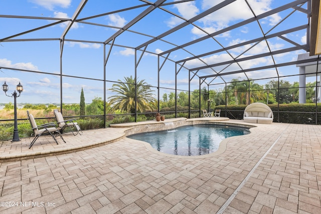 view of pool featuring glass enclosure, a patio area, and pool water feature