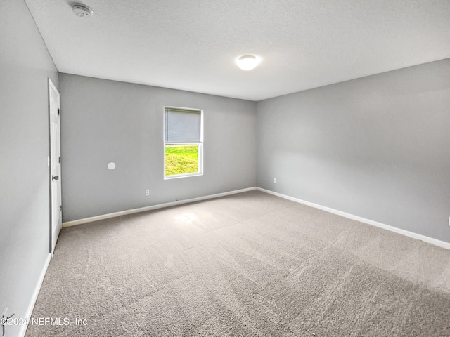 unfurnished room featuring carpet and a textured ceiling