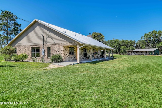 rear view of property featuring a lawn