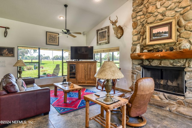 living room featuring a stone fireplace, ceiling fan, and high vaulted ceiling