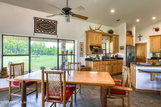 tiled dining area with ceiling fan, lofted ceiling, and sink