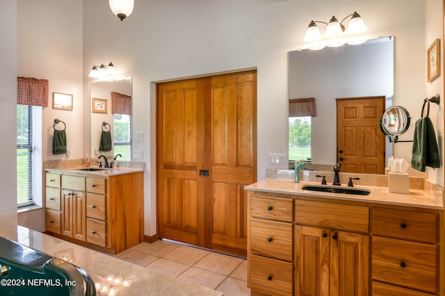 bathroom featuring tile patterned floors, vanity, and a towering ceiling