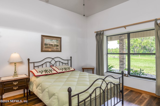 bedroom with dark hardwood / wood-style floors