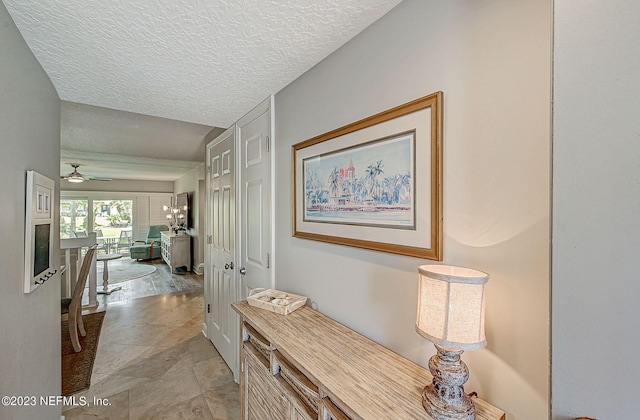 8550 A1A Unit 12122, Saint Augustine, FL 32080 - hallway with a chandelier, light tile flooring, and a textured ceiling