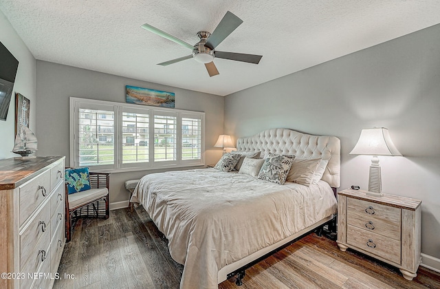 8550 A1A Unit 12122, Saint Augustine, FL 32080 - bedroom with ceiling fan, a textured ceiling, and dark wood-type flooring