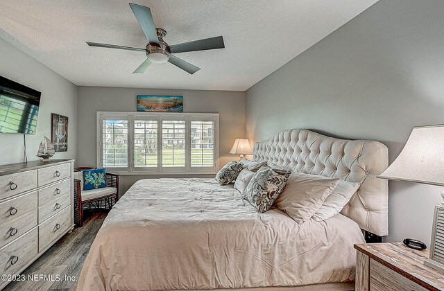 8550 A1A Unit 12122, Saint Augustine, FL 32080 - bedroom with dark hardwood / wood-style flooring, ceiling fan, and a textured ceiling