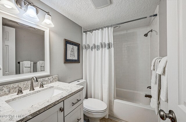 8550 A1A Unit 12122, Saint Augustine, FL 32080 - full bathroom with vanity, toilet, a textured ceiling, and shower / tub combo with curtain