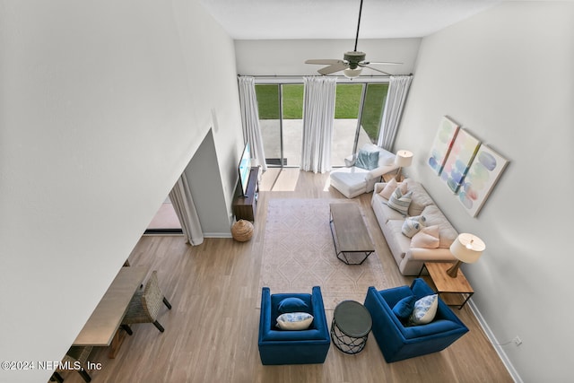 living room with ceiling fan and light wood-type flooring