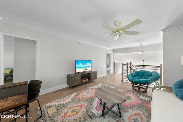 living room featuring ceiling fan, light hardwood / wood-style floors, and a textured ceiling