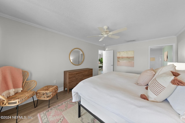 bedroom with ceiling fan, ornamental molding, a textured ceiling, and light wood-type flooring