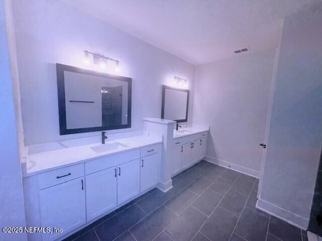 bathroom with a sink, visible vents, walk in shower, and two vanities