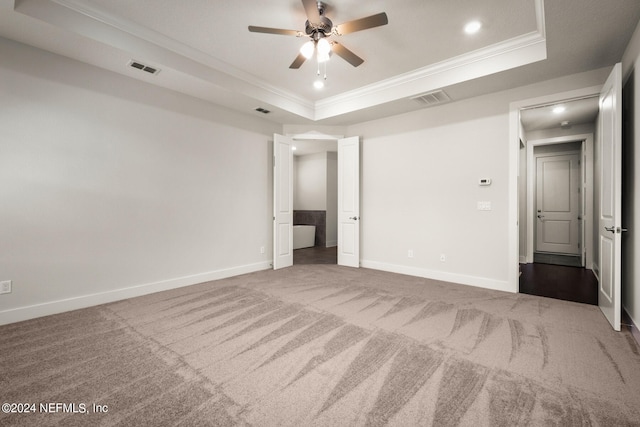 unfurnished bedroom featuring ceiling fan, a tray ceiling, carpet floors, and ornamental molding