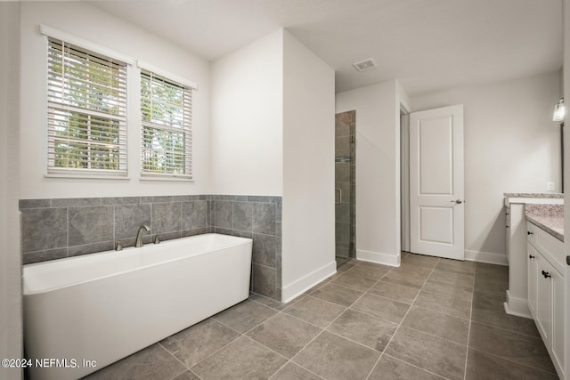 bathroom with tile walls, tile flooring, separate shower and tub, and vanity