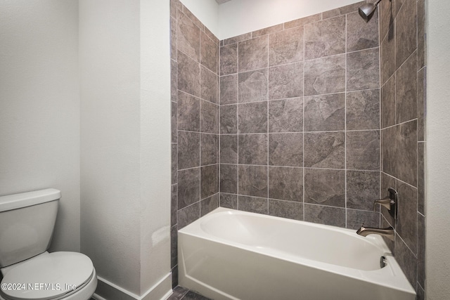 bathroom with toilet and tiled shower / bath combo