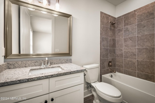 full bathroom featuring tiled shower / bath, toilet, and large vanity