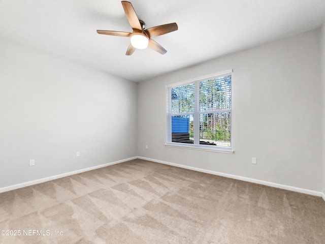 spare room featuring light colored carpet and ceiling fan