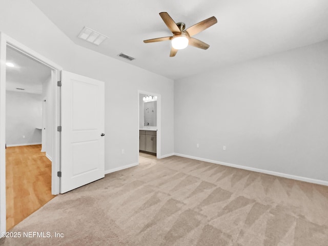 unfurnished bedroom with ensuite bathroom, ceiling fan, and light colored carpet