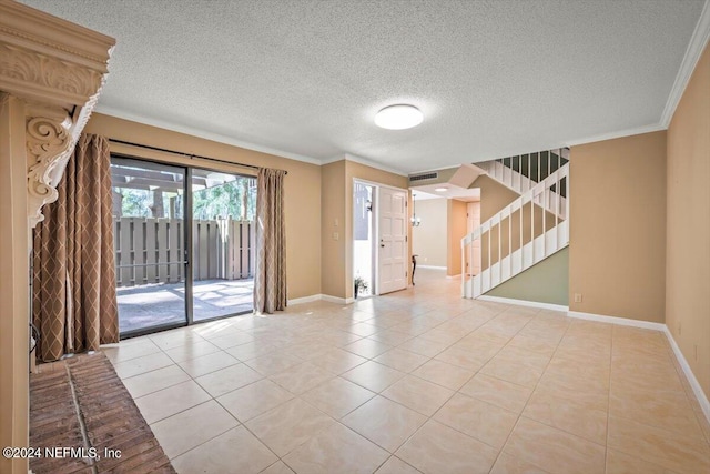 tiled spare room featuring a textured ceiling and ornamental molding