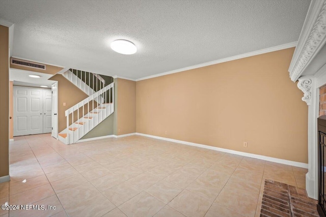 unfurnished living room with a textured ceiling, ornamental molding, and light tile floors