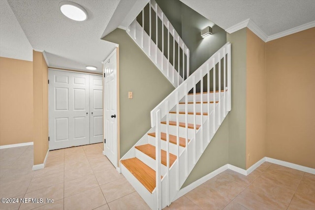 stairway with light tile floors, a textured ceiling, and crown molding