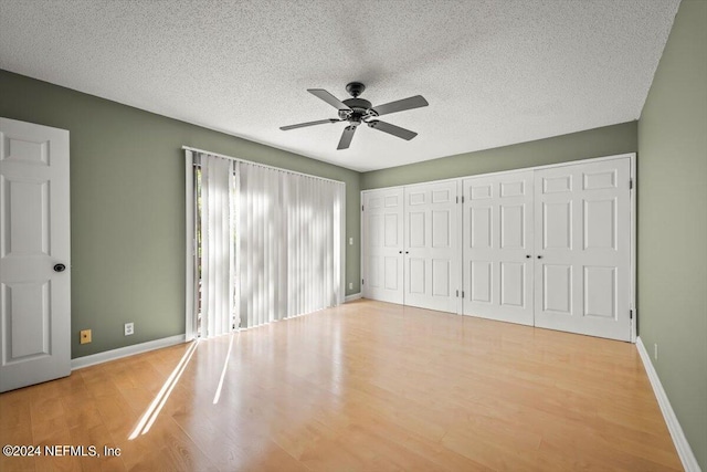 unfurnished bedroom featuring a textured ceiling, ceiling fan, and light wood-type flooring