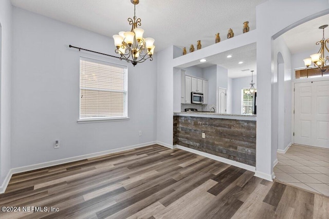 interior space with dark tile floors and a chandelier