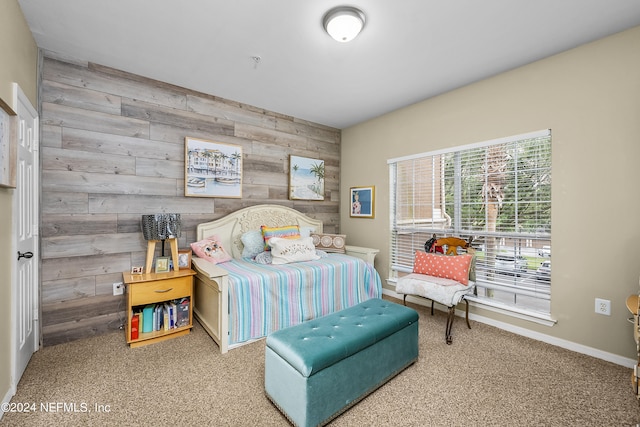 bedroom featuring carpet flooring and wood walls