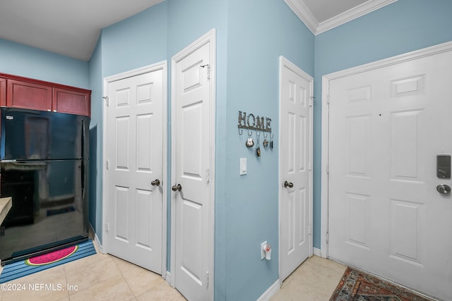 foyer entrance featuring crown molding and light tile patterned flooring