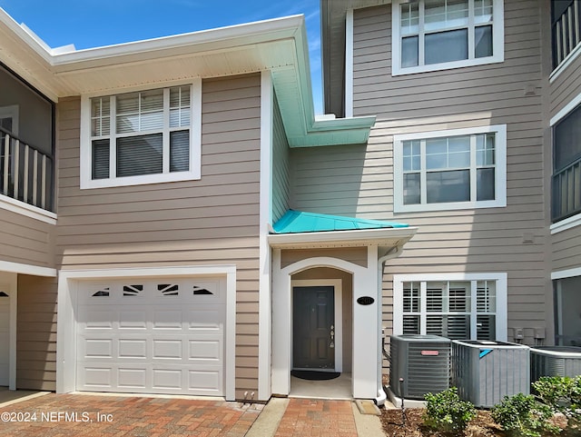 property entrance featuring a garage and central air condition unit