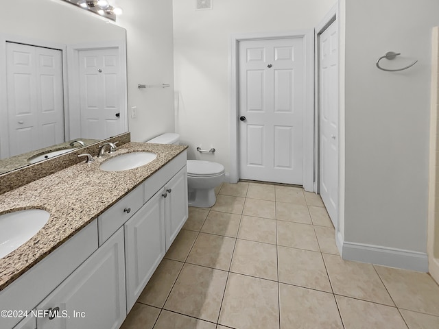 bathroom with tile patterned flooring, vanity, and toilet