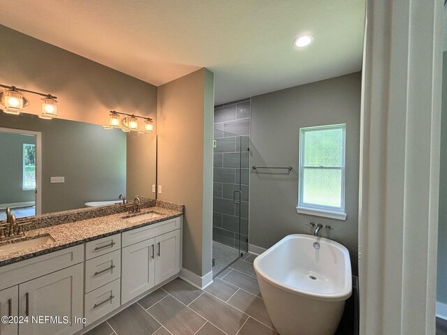 bathroom with tile patterned flooring, vanity, and shower with separate bathtub