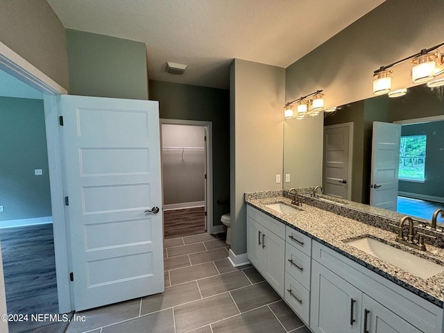 bathroom with toilet, vanity, and tile patterned floors