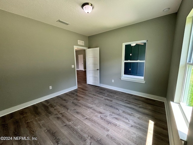 unfurnished room featuring hardwood / wood-style flooring and a textured ceiling