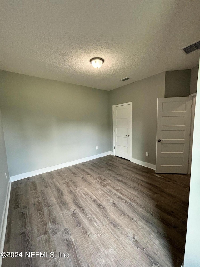 spare room with hardwood / wood-style flooring and a textured ceiling