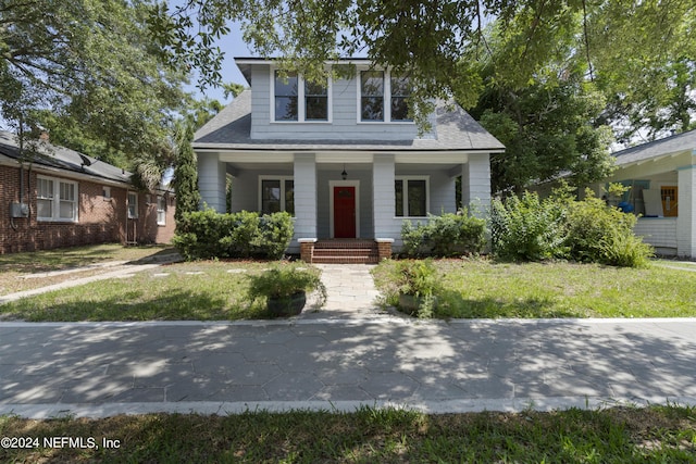 bungalow-style home with a porch and a front lawn