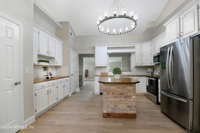 kitchen featuring white cabinets, appliances with stainless steel finishes, backsplash, and light hardwood / wood-style floors