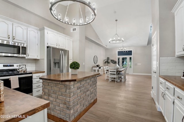 kitchen featuring wooden counters, appliances with stainless steel finishes, light wood-type flooring, high vaulted ceiling, and white cabinetry