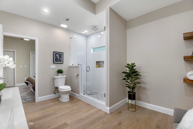 bathroom featuring vanity, hardwood / wood-style flooring, toilet, and a shower with shower door